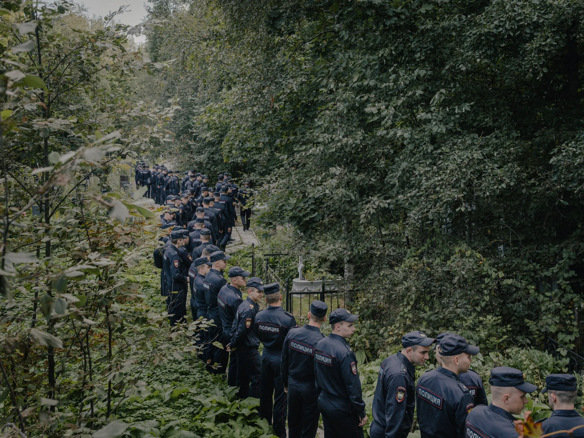 У якийсь момент десятки офіцерів у формі вишикувались уздовж цвинтаря.